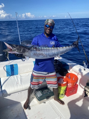 Lenroy with fishing rod on a boat